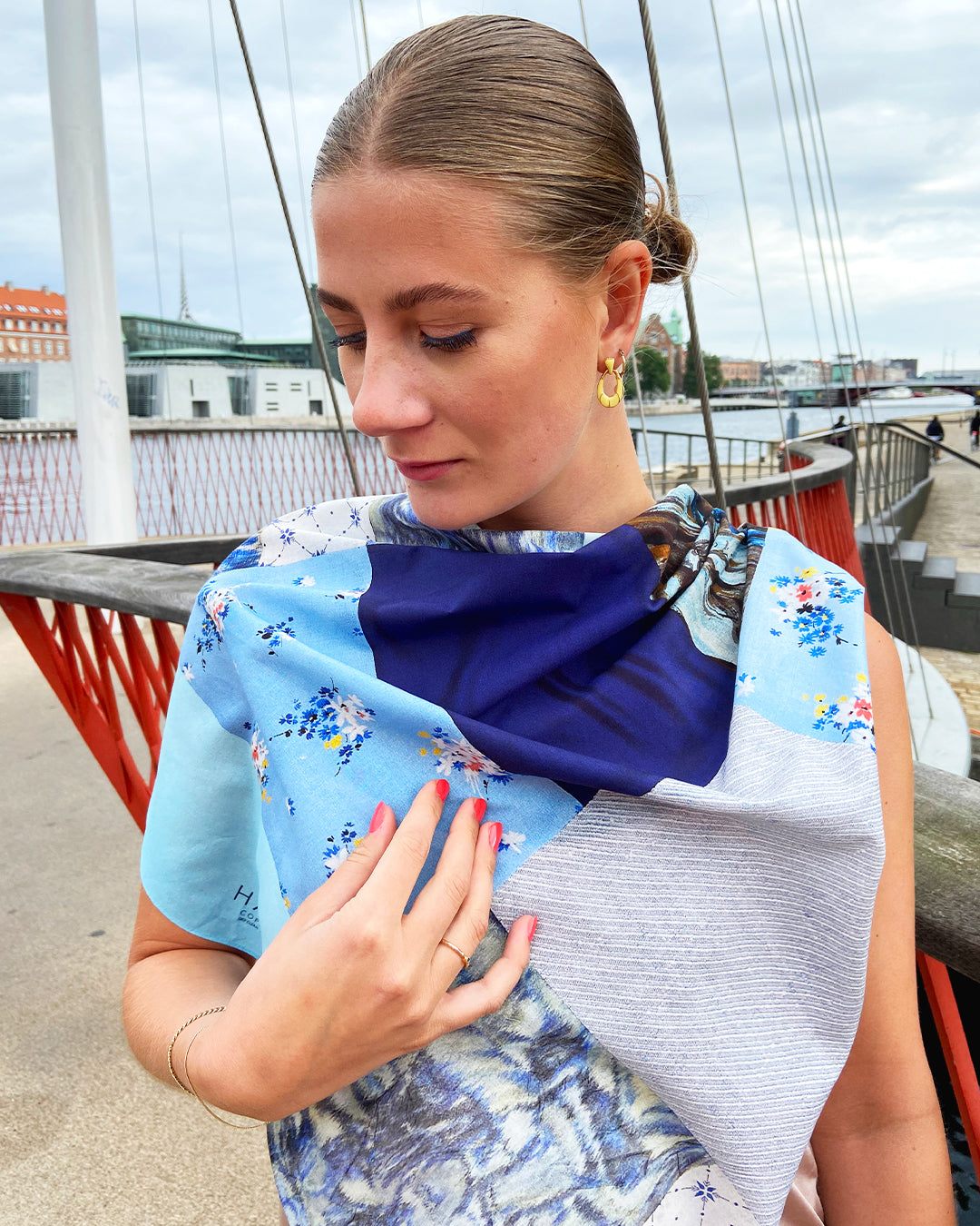 Kvadratisk silketørklæde med blå blomster, silketørklæde i lys blå, silketørklæde med patchworkmønster, Silketørklæde blå farver, Silketørklæde lys blå, silketørklæde multifarvet blåt. silketørklæde med mørk blå farve,  Silketørklæde kvadratisk 65 x 65 cm, Silketørklæde i 100 % ren silke, silketørklæde i ægte silke twill, silketørklæde med design af Susanne Schjerning, silketørklæde med rullede kanter. Giv et silketørklæde i gave. Bæredygtigt silketørklæde i dansk design.