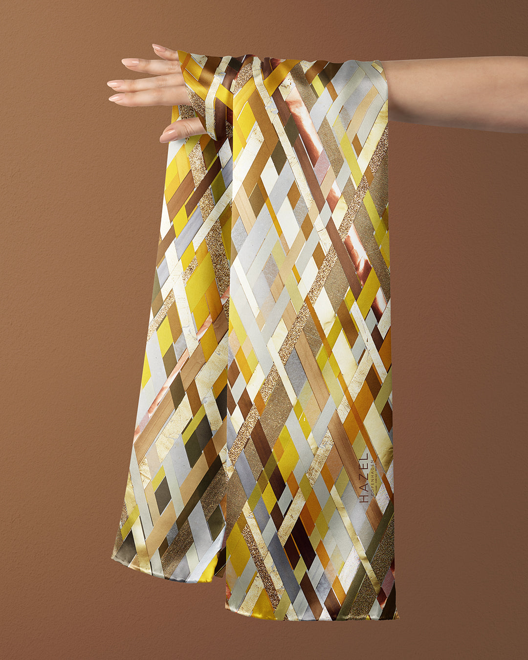 Aflangt silketørklæde i gyldne farver, silketørklæde i gule farver, Silketørklæde brune ternet, Silketørklæde med gule og brune håndmalede tern, Silketørklæde aflangt 160 x 65 cm, Silketørklæde i 100 % ren silke, silketørklæde i ægte silke twill, silketørklæde med design af Susanne Schjerning, silketørklæde med rullede kanter. Giv et silketørklæde i gave. Bæredygtigt silketørklæde i bæredygtig dansk design, silketørklædet der er nemt at binde. 