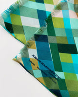Aflangt silketørklæde med harlekintern, grønt silketørklæde, Silketørklæde i turkis farve, Silketørklæde i blå farve, silketørklæde i grøn farve, silketørklæde i multifarvede grønne harlekintern tern,  Silketørklæde aflangt 180 x 65 cm, Silketørklæde i 100 % ren silke, silketørklæde i ægte silke twill, silketørklæde med design af Susanne Schjerning, silketørklæde med rullede kanter. Giv et silketørklæde i gave. Bæredygtigt silketørklæde i dansk design.