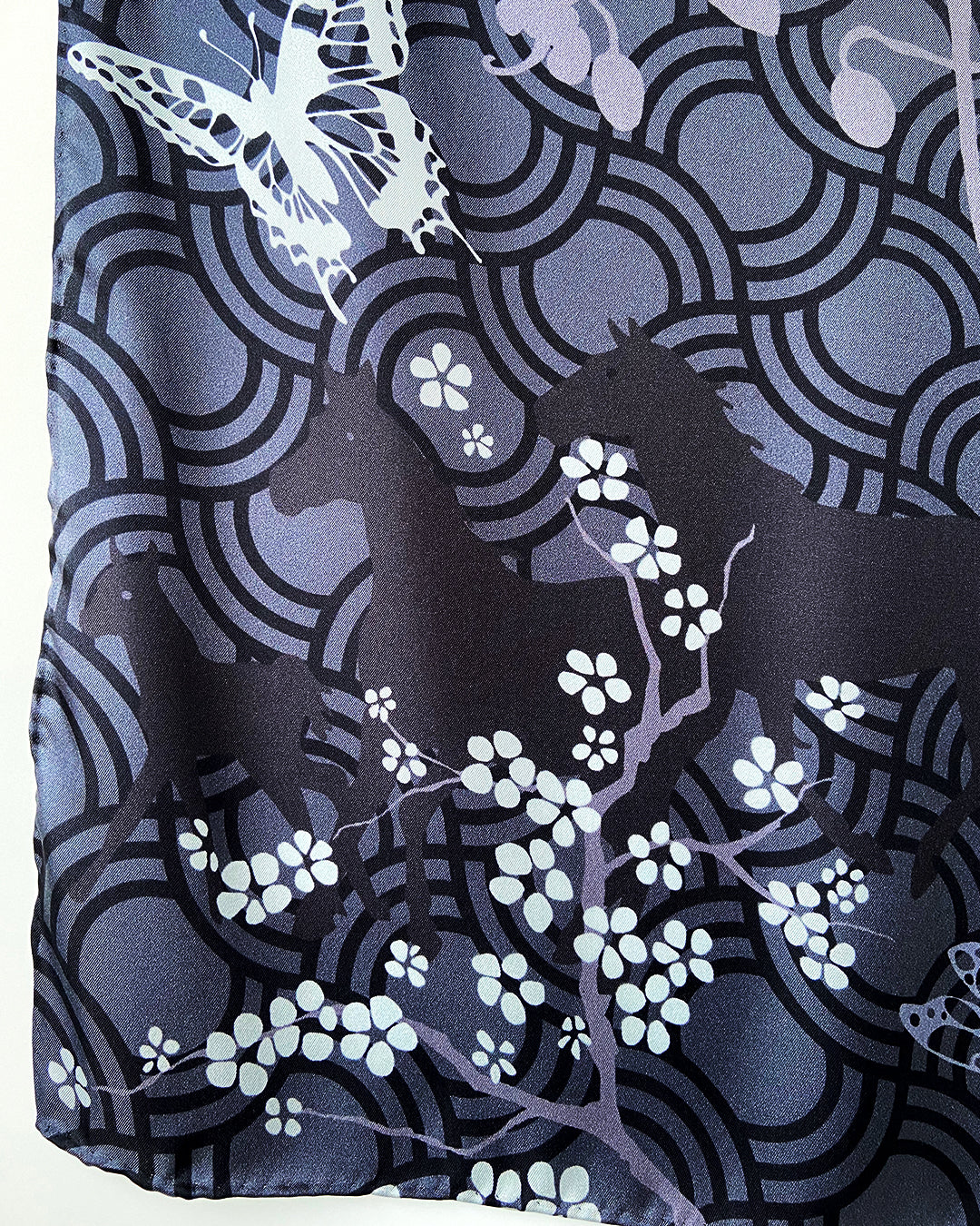 Silketørklæde firkantet, silketørklæde kvadratisk, silketørklæde 90 x90 cm, silketørklæde sort, silketørklæde med kirsebærgrene, silketørklæde i flotte grå og sorte farver, silketørklæde med heste og sommerfugle, silketørklæde med blomster og sommerfugle, silketørklæde i flot design, Silketørklæde i 100 % ren silke, silketørklæde i ægte silke twill, silketørklæde med design af Susanne Schjerning, silketørklæde med rullede kanter. Giv et silketørklæde i gave. Bæredygtigt silketørklæde i dansk design.